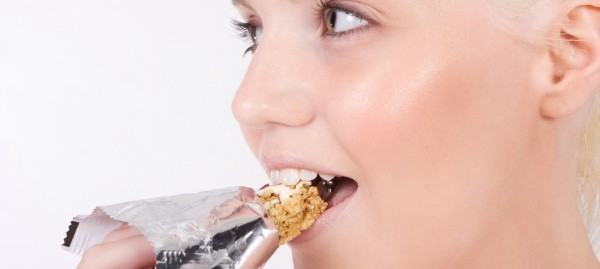 naine sööb proteiinibatooni